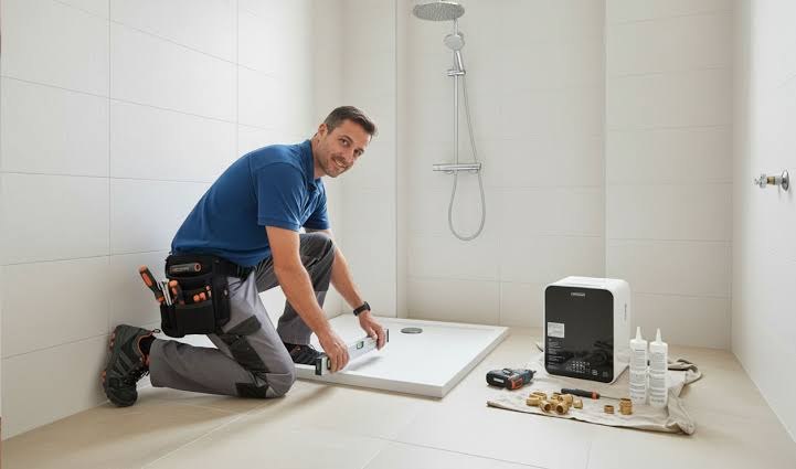 Técnico DR HOGAR instalando un receptáculo de ducha en una remodelación